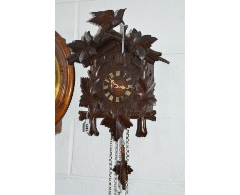A LATE 19TH CENTURY OAK CUCKOO CLOCK, the sable with central bird flanked by leaves, the case similary carved, circular dial 