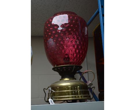 A LARGE BRASS BASED TABLE LAMP WITH DIMPLED CRANBERRY GLASS SHADE, height approximately 50cm