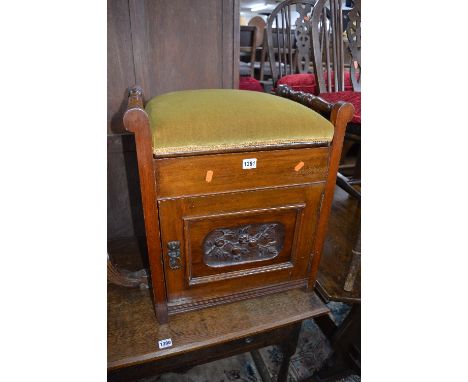 AN EDWARDIAN MAHOGANY PIANO STOOL, with a single carved panel door