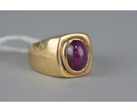 A MODERN GENT'S SINGLE STONE RUBY RING, an oval cabochon ruby measuring approximately 10mm x 8mm, cushion shape head, ring si