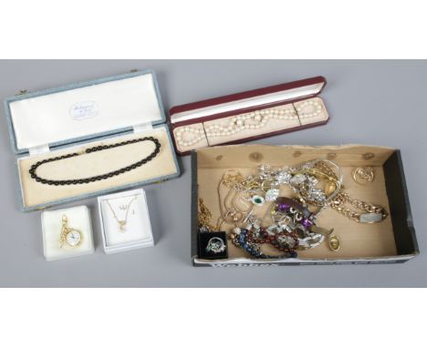 A box of costume jewellery to include simulated pearls, rings, manual nurses watch etc.