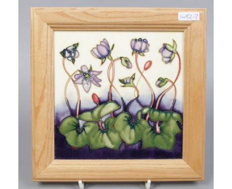 A framed Moorcroft tile decorated with hepaticas, 15.5 x 15.5cm.