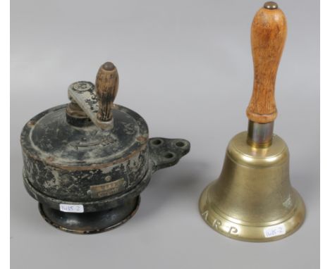 A World War II A.R.P brass bell with turned wooden handle along with a manual hand wound Klaxon.
