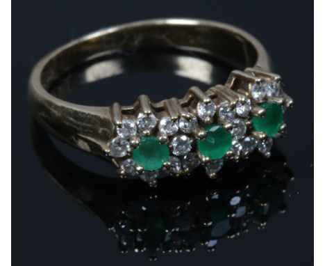 A 9ct gold emerald and diamond triple cluster ring. Size K.