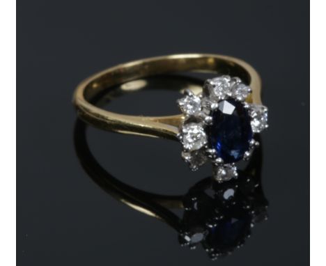 An 18ct gold (tested) sapphire and diamond cluster ring. Sapphire approximately 7mm x 5mm. Size N