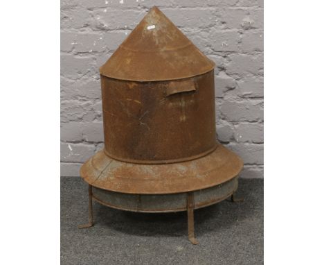 A vintage tin poultry feeder with legs.