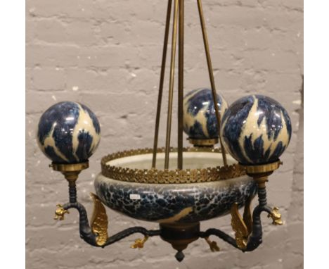 A decorative glass ceiling light having three branches formed as dragons.