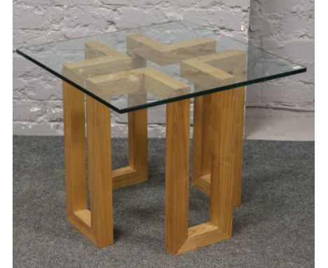 A modern decorative light oak coffee table with glass top.