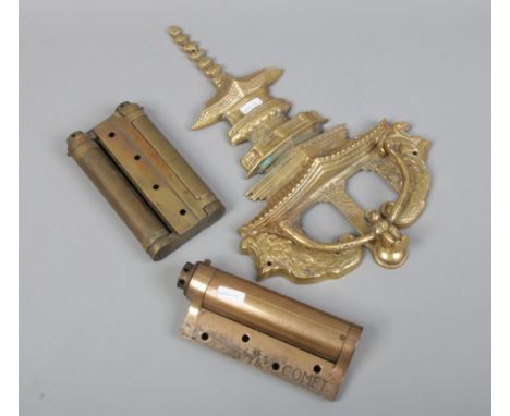 A cast metal Pagoda and monkey door knocker, large brass comet door hinge and a similar bi-fold hinge.
