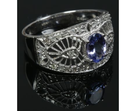 A 14ct white gold, tanzanite and diamond ring with a milgrain openwork setting. Size O.Condition report intended as a guide o