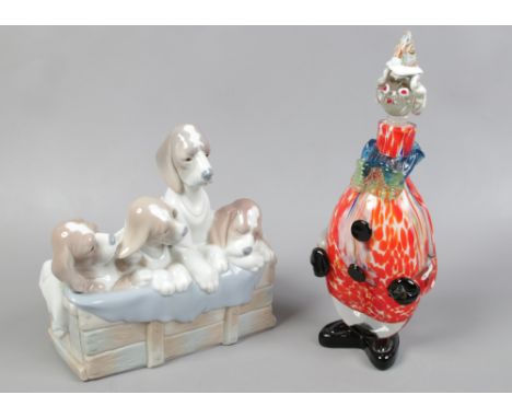 A Lladro model of four dogs on a crate and a Murano glass decanter formed as a clown.