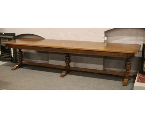 A very large 12 seat oak three pillar refectory table with four plank top and carved frieze, 357cm x 91cm.