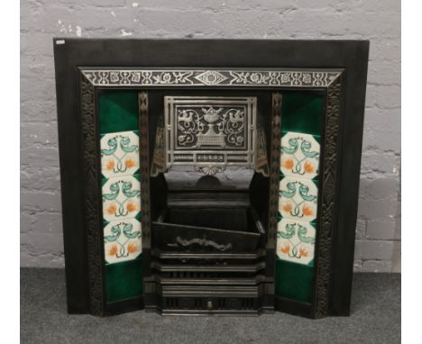 A Victorian style cast iron fire surround with Majolica style tiles.