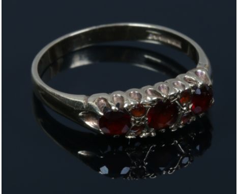 A 9ct gold seven stone garnet ring in a boat shaped setting. Size P.