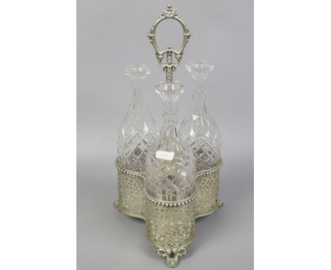A silver plated trefoil decanter stand with pierced decoration and three glass decanters.