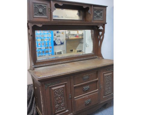 OAK MIRROR BACK SIDEBOARD, circa 1900, having twin cupboard top with central mirrored shelf over a large mirror with carved s