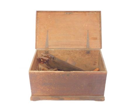 A Victorian stained pine carpenter's tool chest, 40cm H, 79cm W, 48cm D., containing mallets, saws, and further tools.