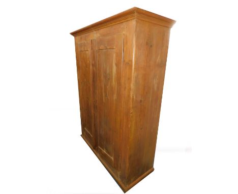 A pine double wardrobe, the outswept pediment over a pair of doors, raised on a bracket foot base, 186.5cm H, 139cm W, 53cm D