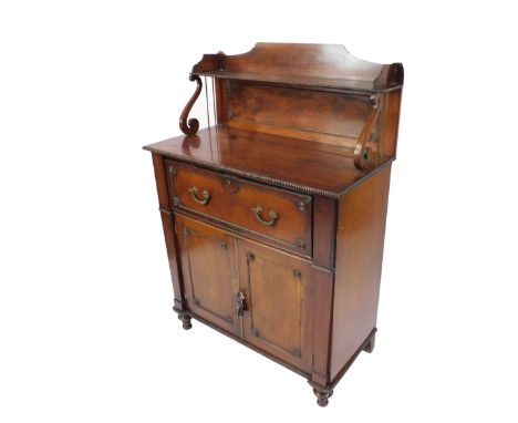 A Regency mahogany secretaire cabinet, with nulled and flamed back with half lyre supports and a plum pudding veneered panel,