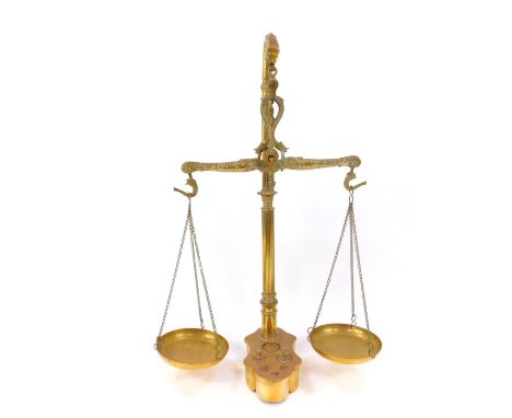 A pair of Victorian brass beam scales, with cast dolphin suspension, fluted column, raised on a shaped base inset with six we