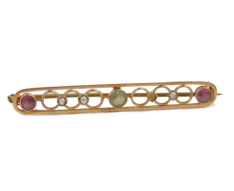 An early 20thC gold suffragette brooch, set with a peridot, amethyst and seed pearls, one seed pearl lacking, 2.5g.