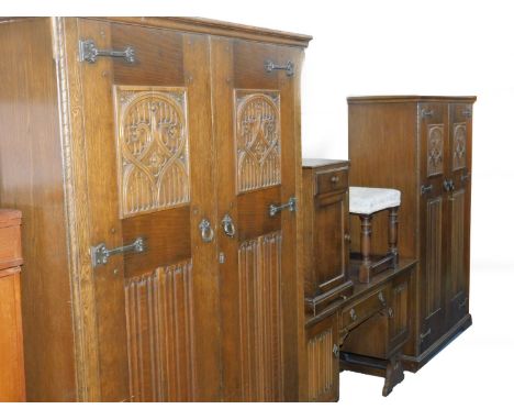 A 20thC oak bedroom suite, with Gothic tracery and linenfold carved panelling, comprising a double wardrobe, raised on bracke