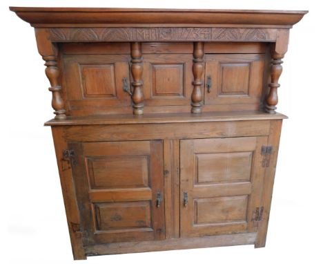 A George II oak court cupboard, with later alterations, the outswept pediment over a leaf carved frieze, bearing carved initi