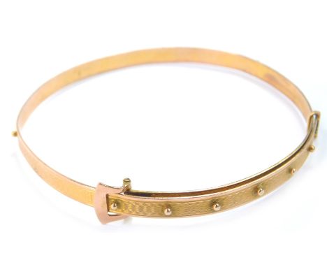 A Victorian two colour gold belt and buckle bangle, with engine turned decoration, 9.6g.