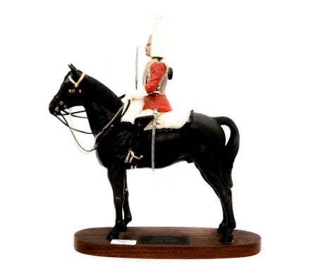 Beswick figurine of a lifeguard mounted on horseback with drawn sword.