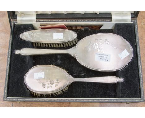 A cased four piece silver dressing table set, comprising of mirror, hair brush, clothes brush and comb, Birmingham, 1956, mak