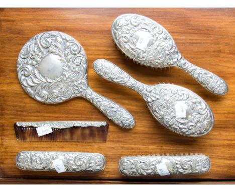 A sterling silver dressing table set by B & Co. Birmingham to include four Brush's, Hand Mirror and Comb. (6)