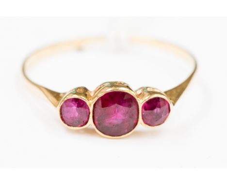 A three stone ruby ring, 18 carat gold ring size R