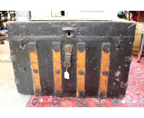 A 19th Century American steamer trunk with canvas and wooden bindings, bearing maker's label