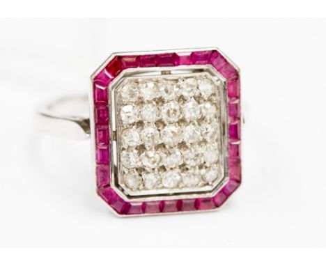 A diamond and ruby white metal cluster ring, the centre with old cut diamonds and surrounded by a ruby border, ring size R, 6