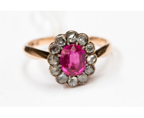 A ruby cluster ring to the centre within a border of twelve rose cut diamonds, stamped 14ct