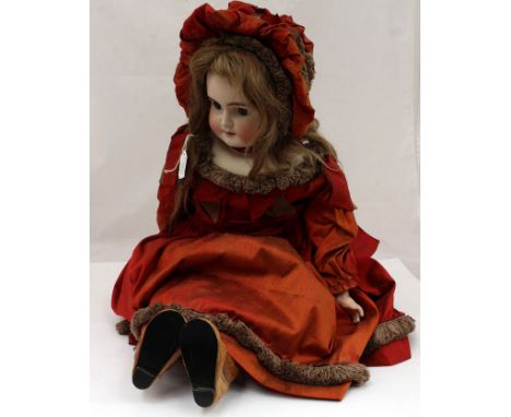 A Victorian head and shoulders bisque porcelain doll, with wide open glass eyes, an open mouth with teeth circa possibly 1890