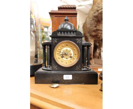A slate mantel clock, gilt dial, Roman numerals, flanked by pillars 