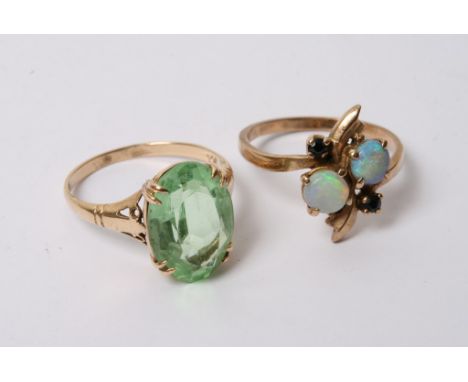 A gold and opal set ring with another green stone set ring