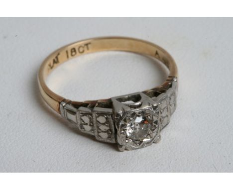 An 18ct gold and platinum ring inset with a solitaire diamond 