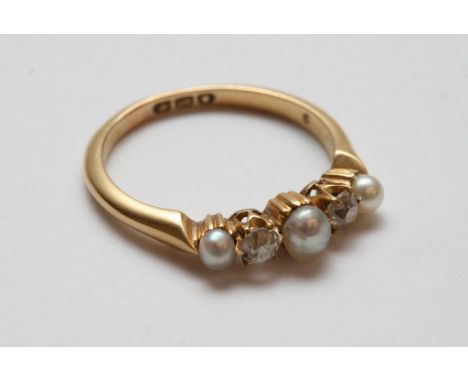 An 18ct gold ring set with a row of old cut diamonds and pearls