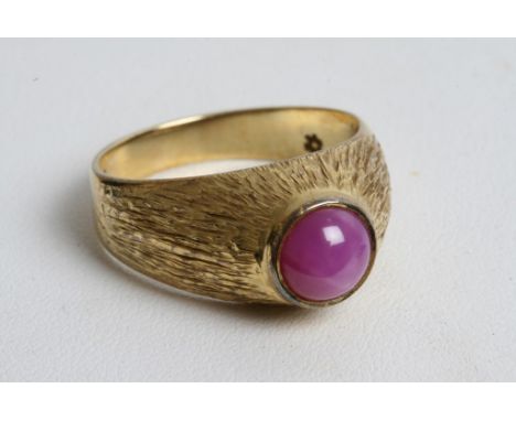 An 18ct gold ring inset with purple sapphire cabouchon. 