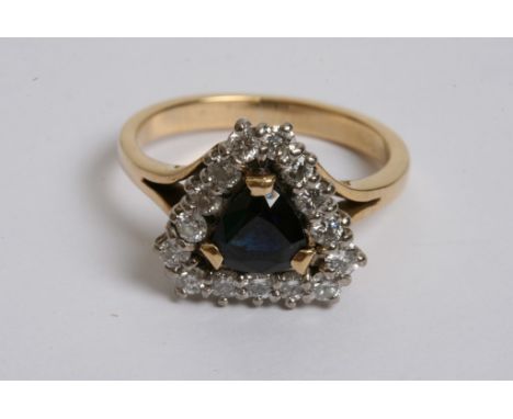 An 18ct gold ring with a blue sapphire flanked by diamonds and of rectangular shape 