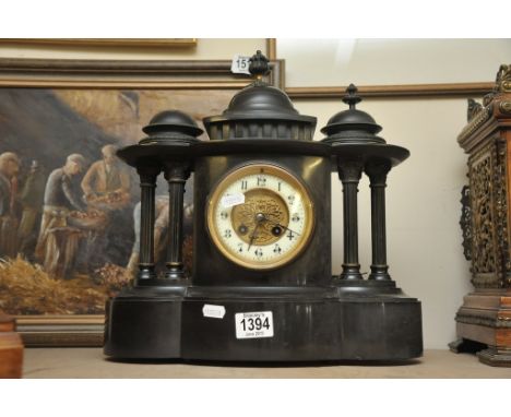 A black slate mantle clock with column supports