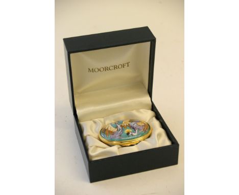 A boxed Moorcroft enamel trinket box featuring a pair of exotic birds to lid.