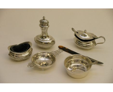 A silver condiment set and a silver tea strainer with stand