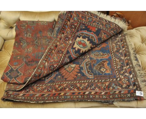 An Afghan style carpet decorated with geometric pattern in blue iron red ground