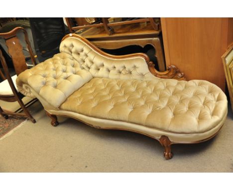 A Victorian walnut chaise longue with gold button back upholstery and carved cabriole legs. 
