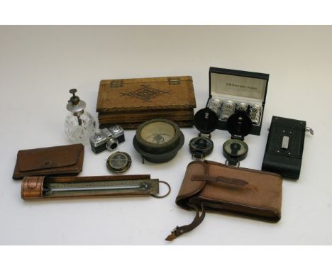 A box containing Soho All Distance camera, Mikroma minature, compasses, perfume bottles, thermometer,  other objects. 
