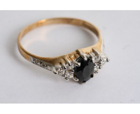 A 9ct gold ring set with a blue sapphire and diamond chips