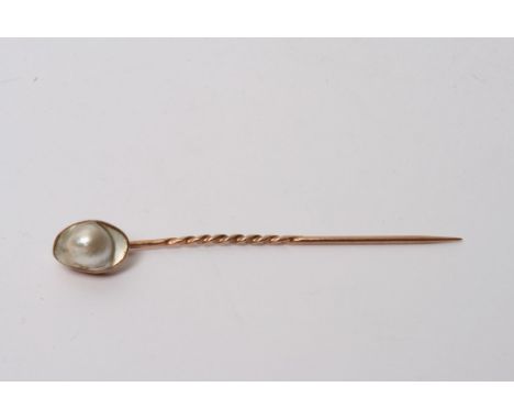 A vintage gold tie pin inset with a pearl 